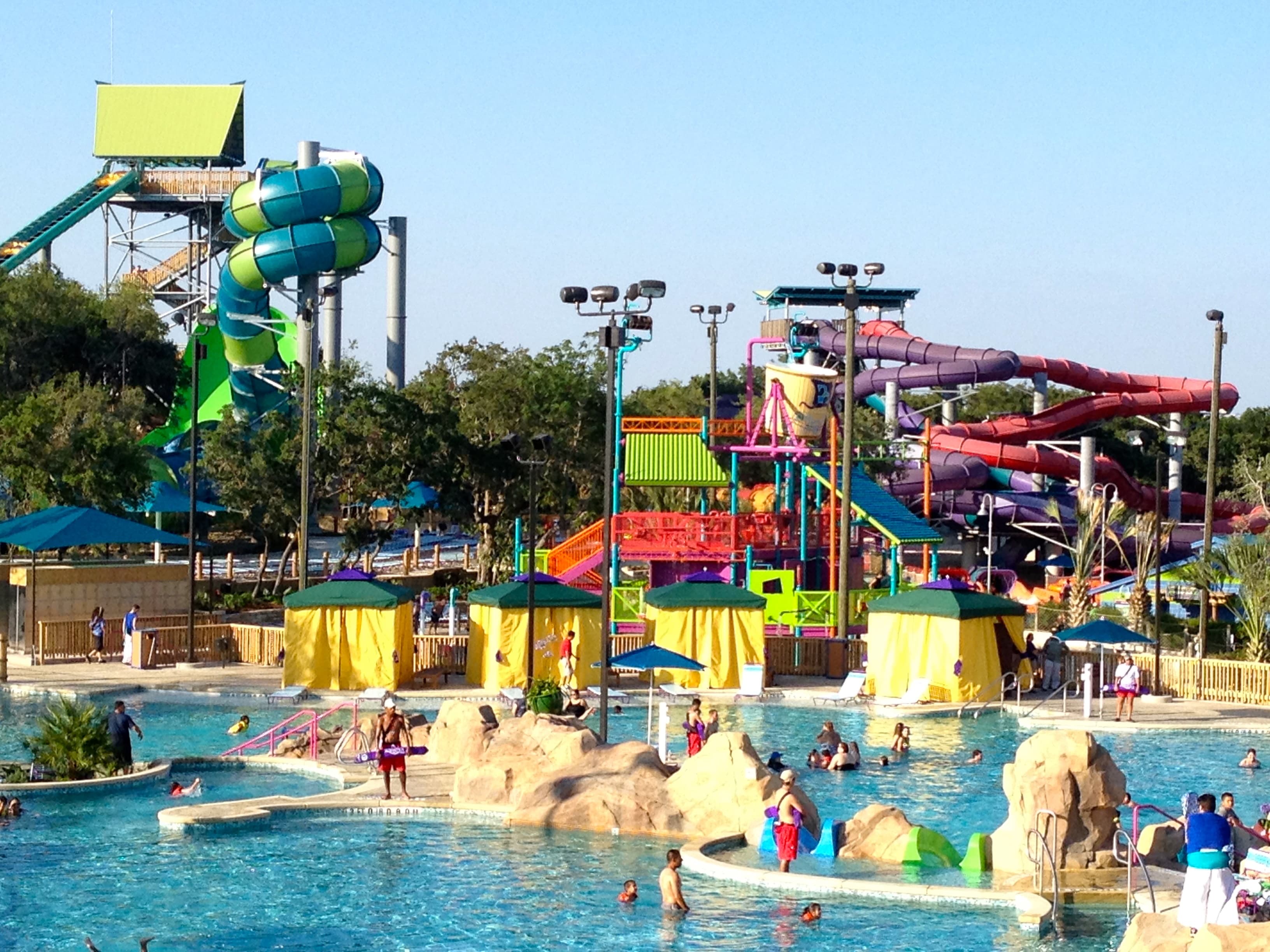 Colorful water slides and a pool at an outdoor water park on a sunny day